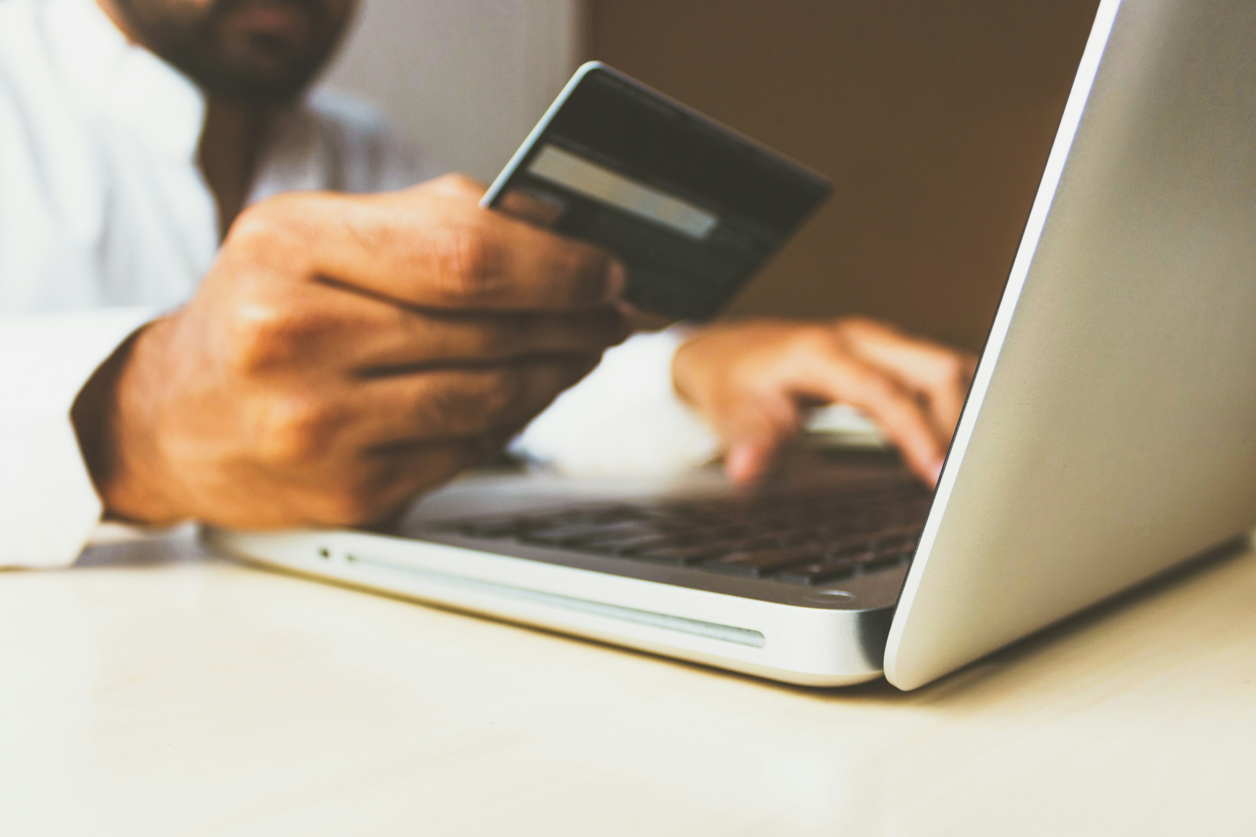 rupixen-Q59HmzK38eQ-unsplash Un hombre mira los datos su tarjeta antes de hacer una compra sostenible online