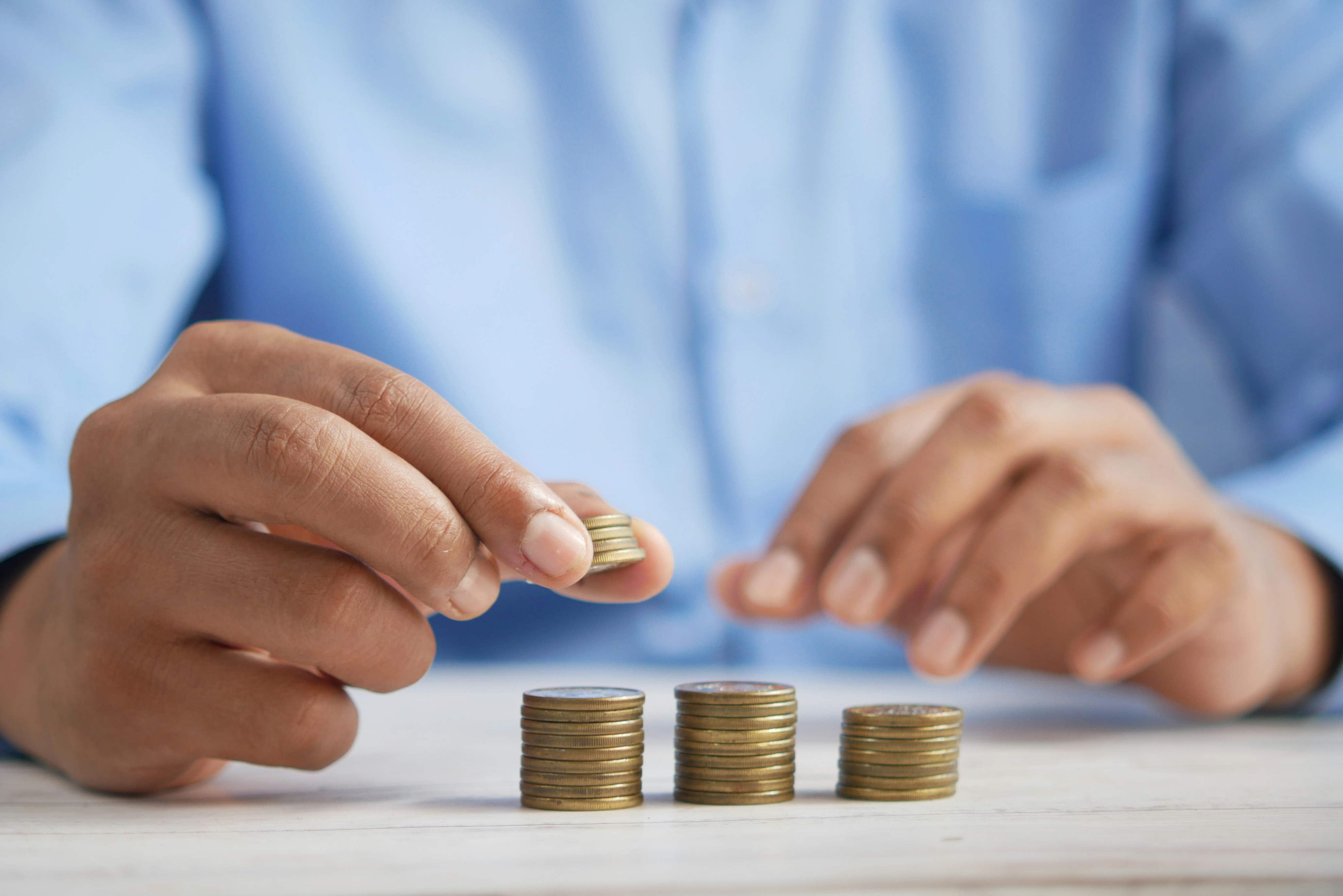 El ahorro resulta clave para poder hacer frente a hipoteca o alquiler Las manos de un adulto reparte monedas en montones para pagar los gastos del hogar
