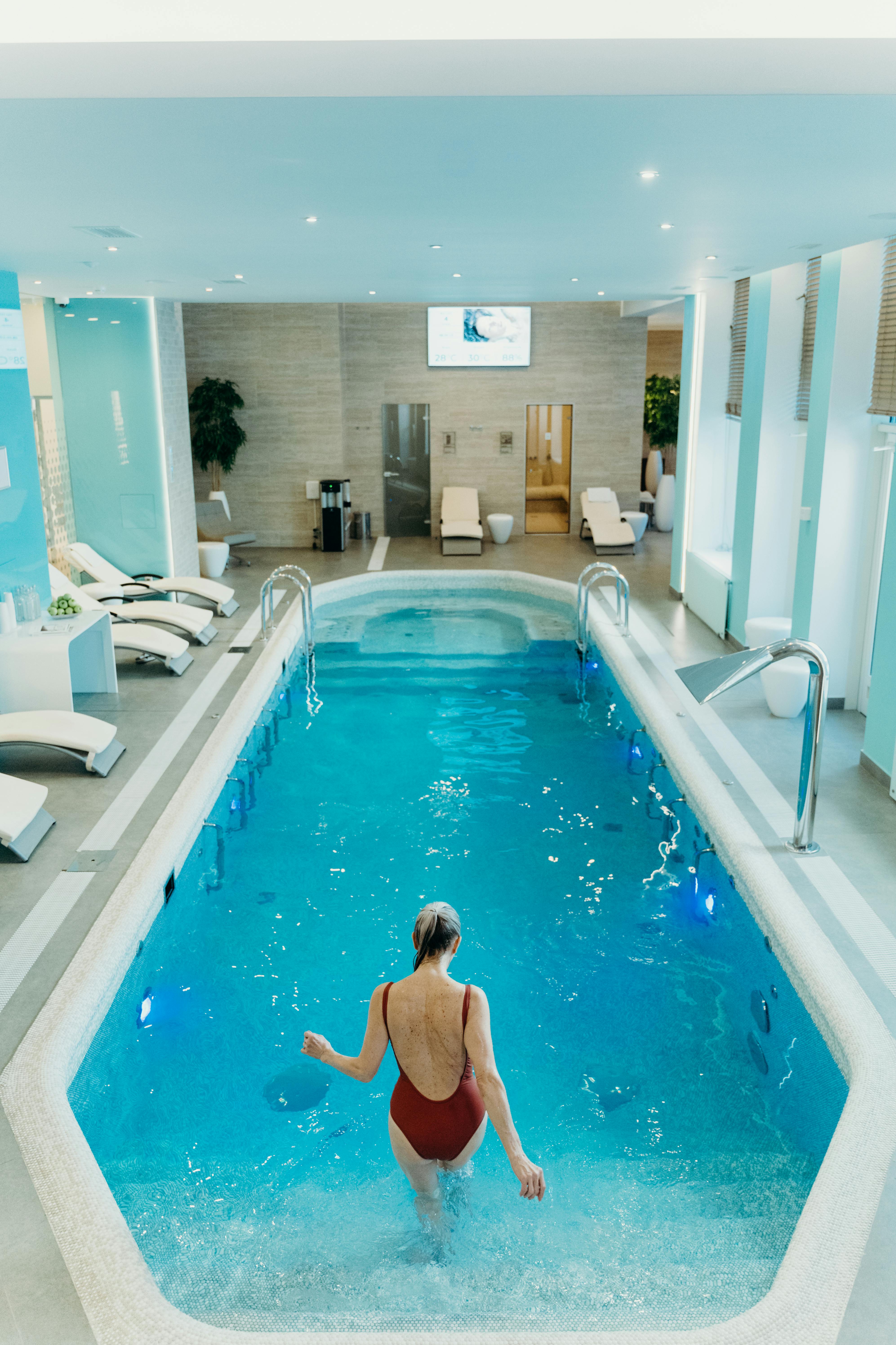 viajar_balneario Una mujer, en la piscina interior de un balneario blanco.