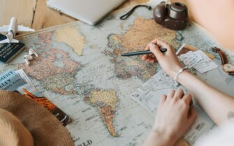 Unas manos señalando con un bolígrafo el continente europeo en un mapa.