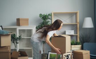 Una joven de alquiler ayudando con un caja de mudanza