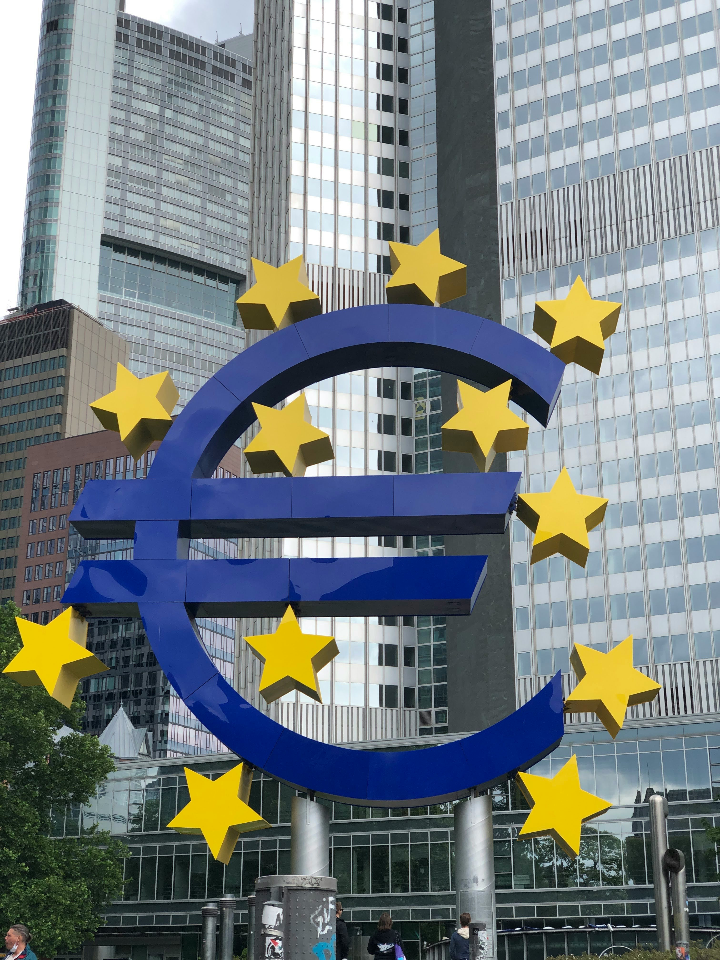 Símbolo del Euro frente a los edificios Entidad pública que asegura el poder invertir en deuda pública